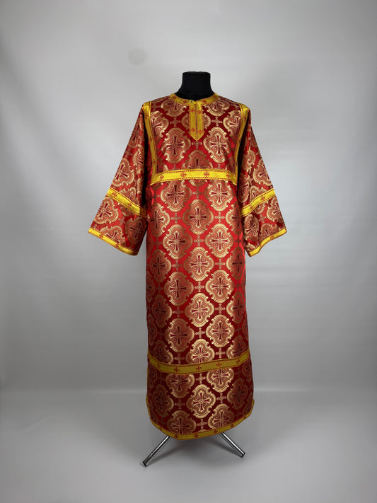 Red and gold embroidered religious robe on a mannequin against a gray background