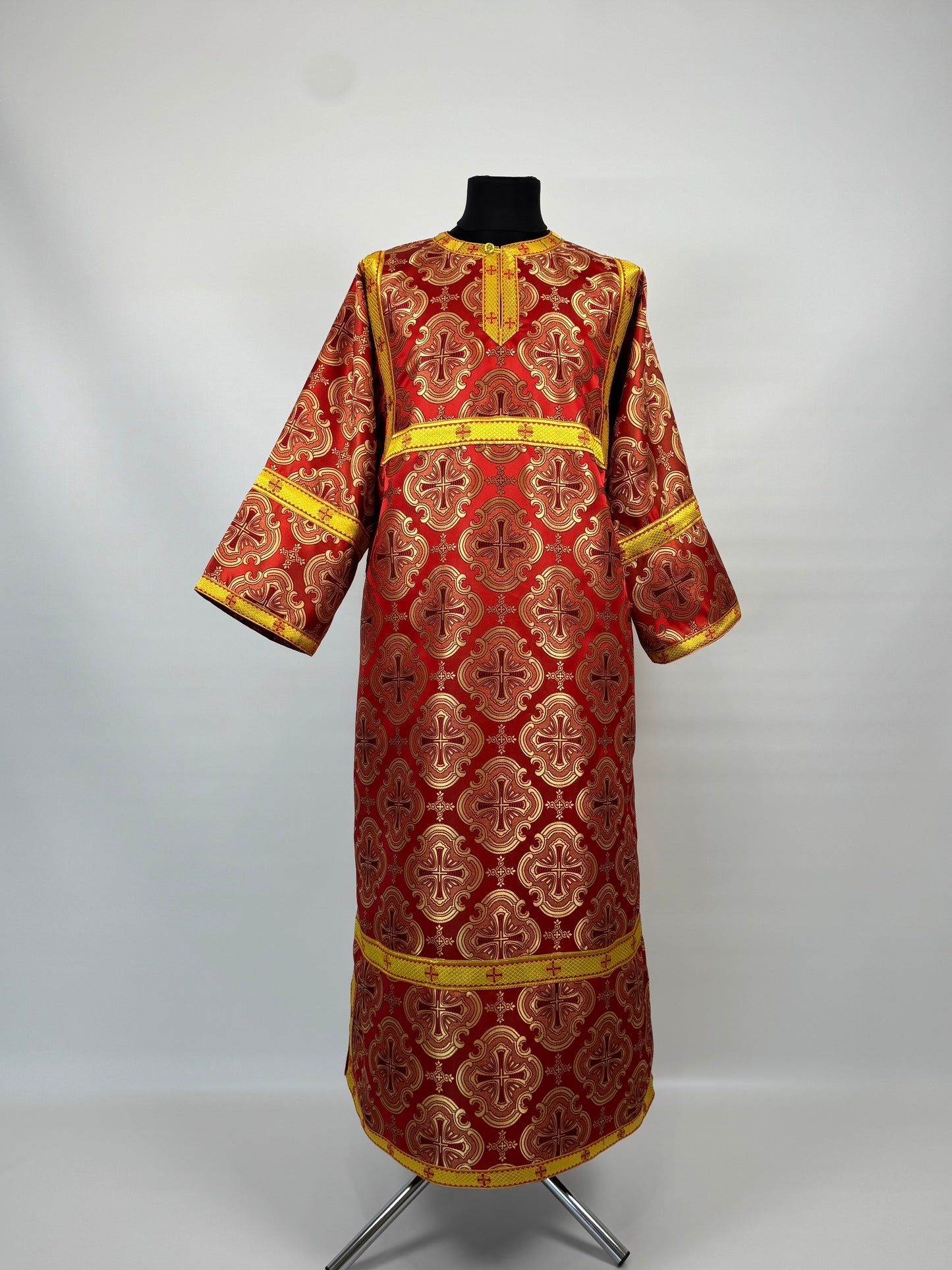 Red and gold traditional garment on a mannequin against a white background