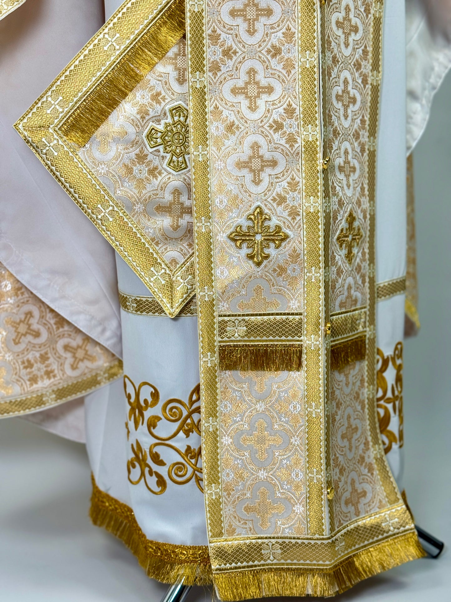 Decorative liturgical vestment with gold embroidery on a white background