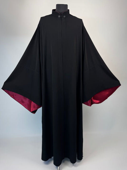 Black outer cassock with burgundy lining on the sleeves