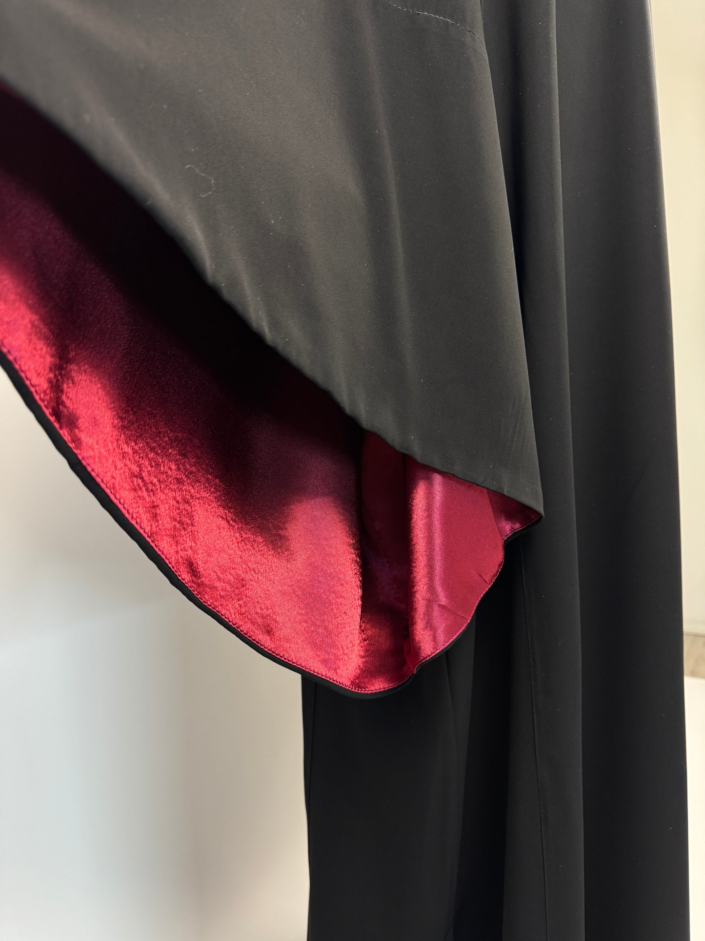 Black outer cassock with burgundy lining on the sleeves
