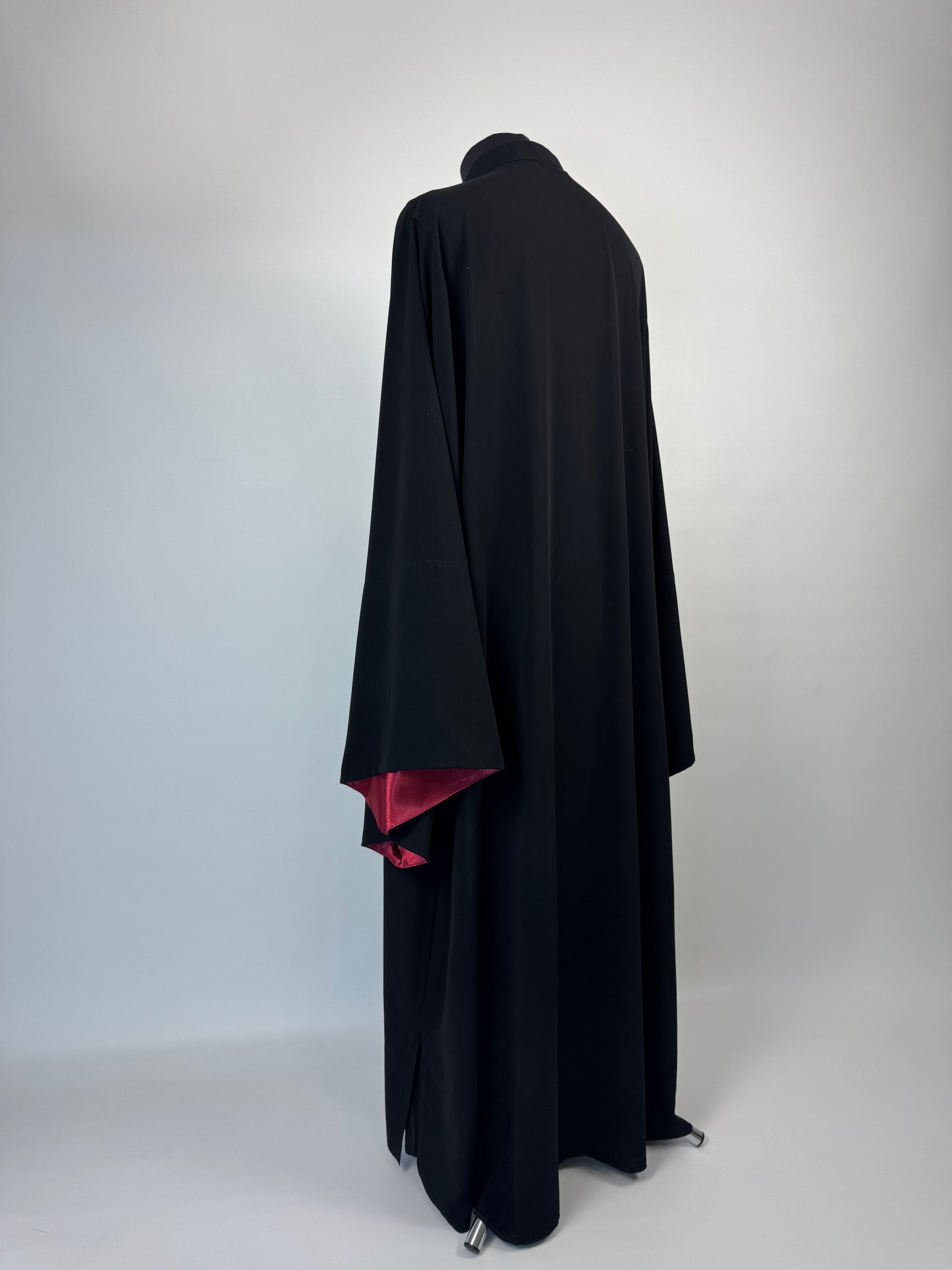 Black outer cassock with burgundy lining on the sleeves