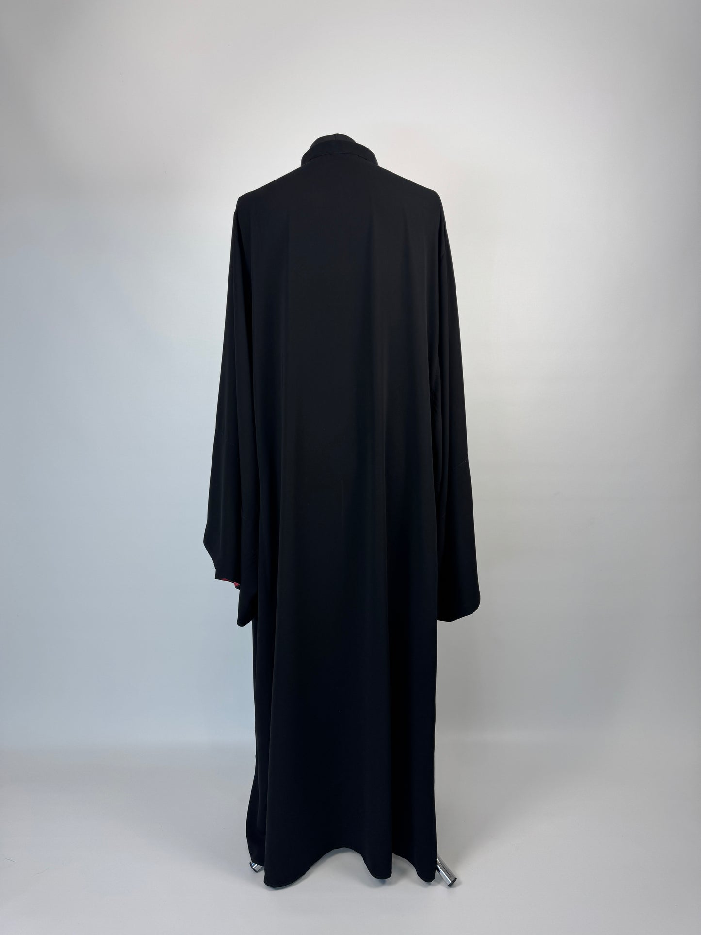 Black outer cassock with burgundy lining on the sleeves